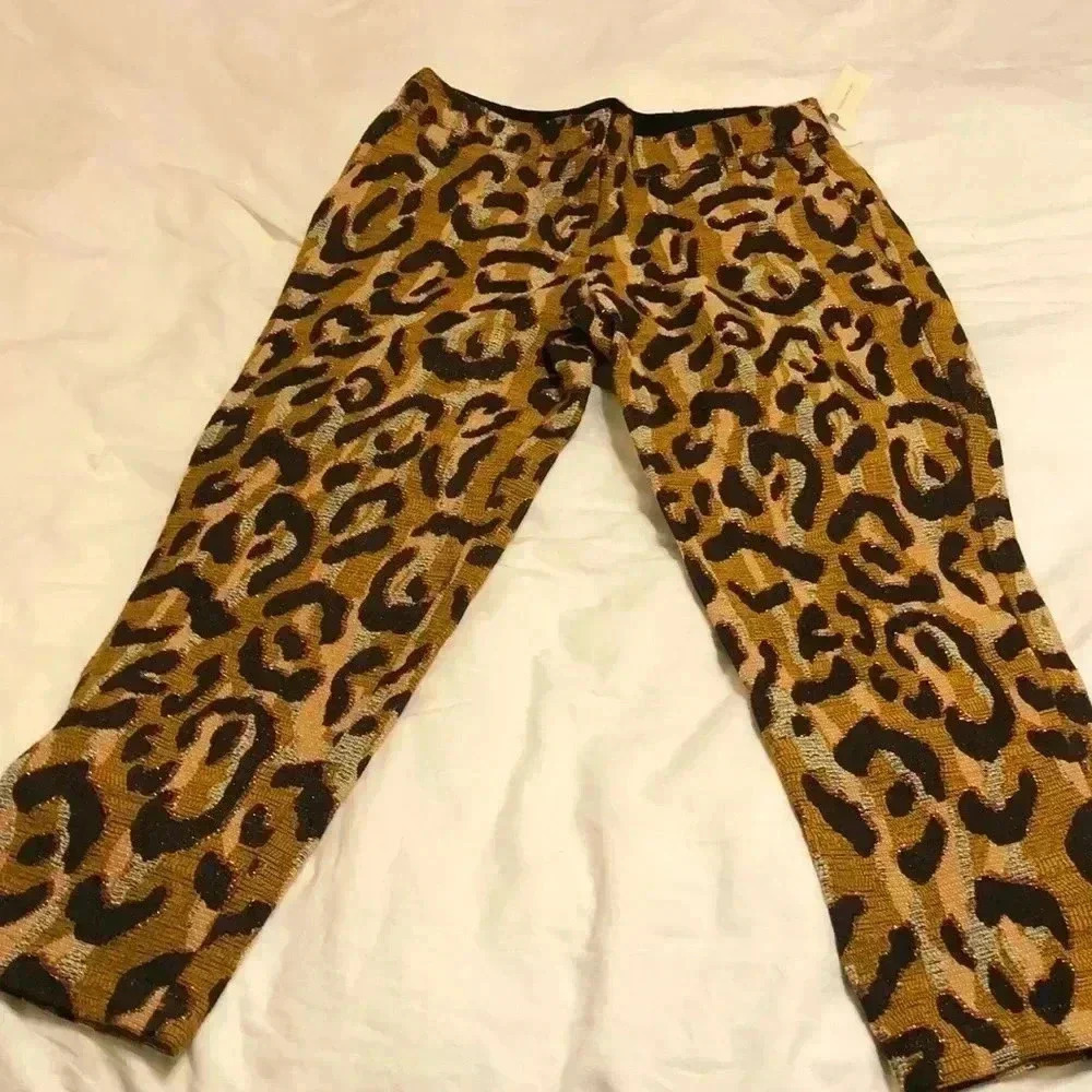 Anthropologie slacks with gold, brown, white, black, red, and silver design.